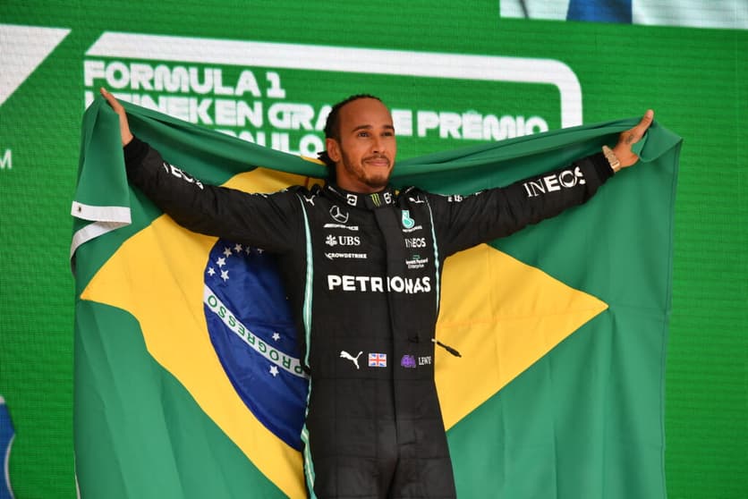 Lewis Hamilton venceu o GP de São Paulo em Interlagos e se vestiu com a bandeira do Brasil no pódio (Foto: AFP)